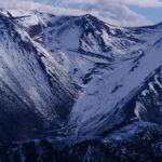 Snowy Peaks Under A Cloudy Blue Sky