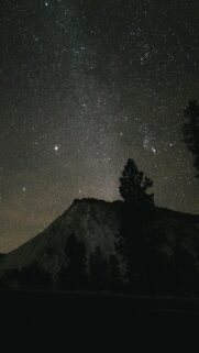 Breathtaking Starry Night Sky Over Mountain Peak Wallpaper