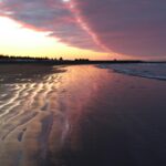 sunset-over-a-wet-beach-with-colorful-clouds