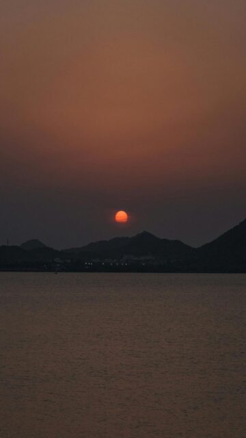 Soothing Mobile Wallpaper: Sunset Over Dark Mountains And Calm Water