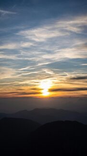 Breathtaking Sunset Over Mountain Range with Wispy Clouds