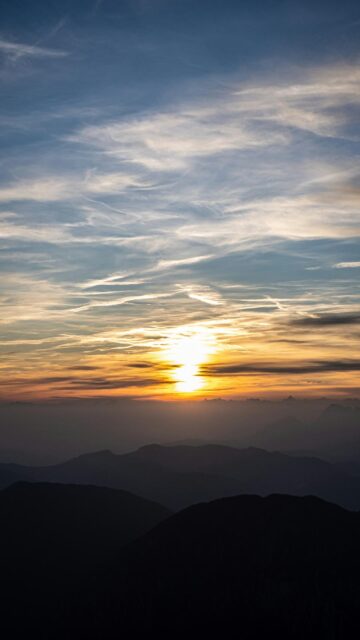 Breathtaking Sunset Over Mountain Range with Wispy Clouds