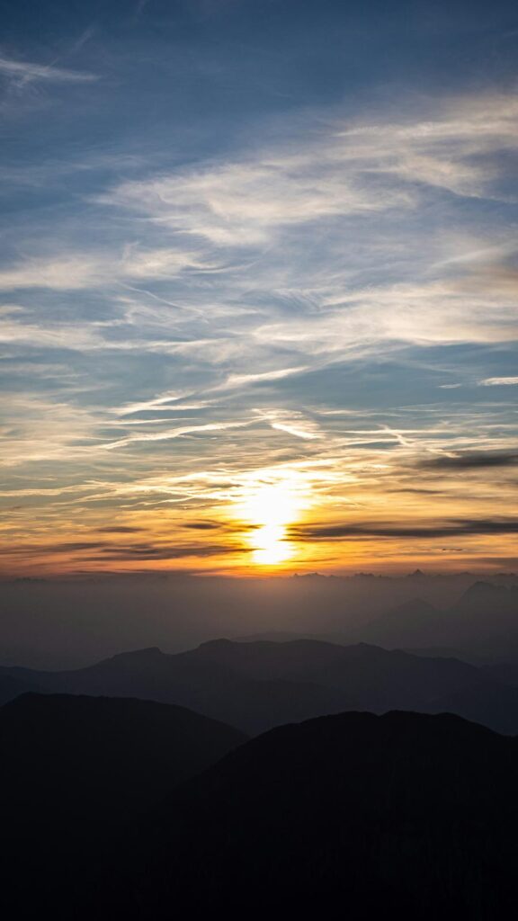 Breathtaking Sunset Over Mountain Range with Wispy Clouds