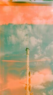 Cloudy Skies Meet Modern Architecture: Tall Communication Tower Wallpaper