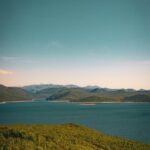 Vast Blue Lake Surrounded by Green Hills and Mountains