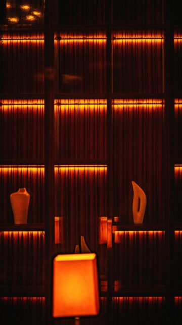 Cozy Warmth: Orange Lights on Shelves with Vases