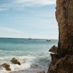 Sandy Beach Waves with Rocky Cliffs Mobile Wallpaper