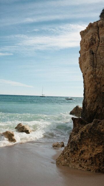 Sandy Beach Waves with Rocky Cliffs Mobile Wallpaper