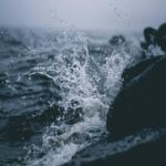 Cloudy Day Waves Against Rocks