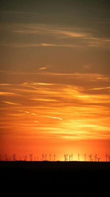 Vibrant Sunset Silhouette of Wind Turbines