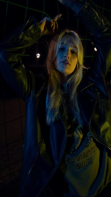 Nightly Vibes - Woman in Leather Jacket Behind Fences