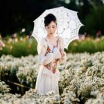 Vintage Elegance: Woman in Field with Umbrella