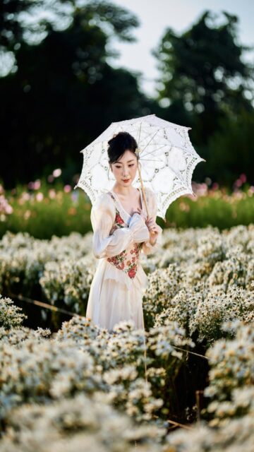 Vintage Elegance: Woman in Field with Umbrella