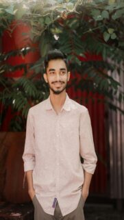 Young Man With Beard Smiling Hands In Pockets