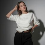 Young Woman Posing in White T-Shirt and Black Pants