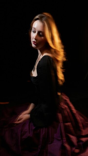Young Woman With Flowing Hair In A Dark Dress