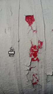 Minimalist Nuke Rest Logo on Cracked White and Red Paint Texture Wallpaper