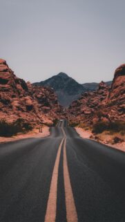 Scenic Desert Road Trip Through Red Rock Mountains Mobile Wallpaper