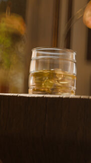 Golden Whiskey Pouring into Glass with Ice Cubes Mobile Wallpaper