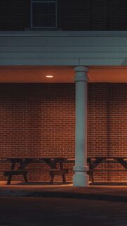 Minimalist Brick Wall Night Scene with Wooden Bench Mobile Wallpaper