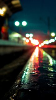 Stunning Rain Soaked Railway Track with Cinematic Bokeh Lights Mobile Wallpaper