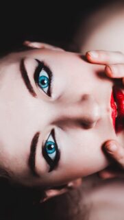 Stunning Close Up Portrait of Woman with Vibrant Blue Eyes and Bold Red Lips Wallpaper