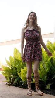 Beautiful Young Woman in Floral Summer Dress Standing by Tropical Plants Wallpaper