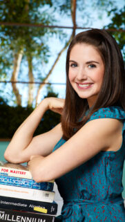 Alison Brie Smiling Portrait with Books Mobile Wallpaper HD
