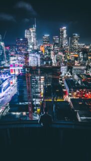Stunning Night Cityscape Rooftop View with Lone Observer Wallpaper