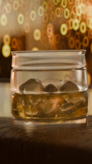 Glass of Whiskey with Ice Cubes Bokeh Background Mobile Wallpaper