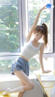 Stunning Asian Girl Stretching in Sunny Classroom High Quality Wallpaper