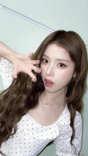 Beautiful K-Pop Idol with Wavy Brown Hair in Polka Dot Outfit Mobile Wallpaper