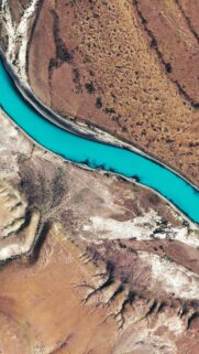 Stunning Aerial View of Turquoise River Winding Through Arid Desert Landscape Wallpaper