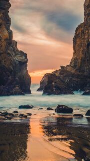 Breathtaking Ocean Sunset Between Rugged Coastal Cliffs Mobile Wallpaper