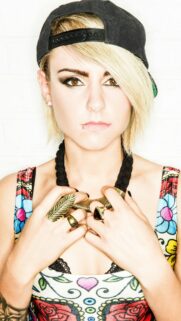 Stunning Portrait of a Blonde Woman in a Black Cap and Floral Top Wallpaper