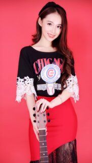 Beautiful Young Woman Holding Guitar Against Vibrant Red Background Wallpaper