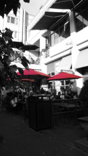 Stunning Black and White Street Cafe with Vibrant Red Umbrellas Wallpaper