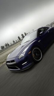 Stunning Dark Blue Nissan GT R Sports Car Moving Fast on Race Track Wallpaper