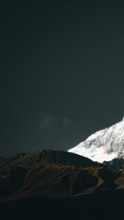 Minimalist Snowy Mountain Peak Against Dark Stormy Sky Mobile Wallpaper
