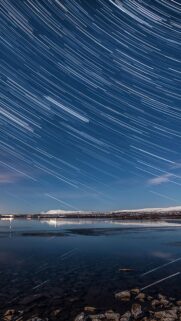 Breathtaking Star Trails Over Frozen Lake Landscape Mobile Wallpaper