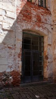 Rustic Abandoned Building Entrance with Weathered Red Brick Wall Mobile Wallpaper
