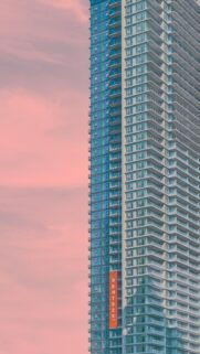 Minimalist Skyscraper Against a Pastel Pink Sunset Sky Mobile Wallpaper