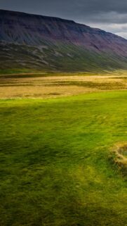 Stunning Icelandic Valley Landscape with Rolling Green Hills and Dramatic Mountains Wallpaper