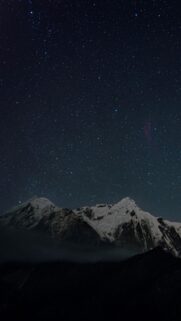 Breathtaking Night Sky over Snowy Mountain Peaks Mobile Wallpaper