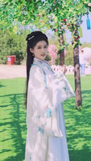 Beautiful Chinese Traditional Hanfu Girl Standing in a Sunny Garden Wallpaper