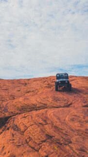 Jeep Off-Roading on Red Rock Desert Landscape Mobile Wallpaper