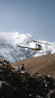 Helicopter Over Snowy Mountain Peaks Adventure Phone Wallpaper