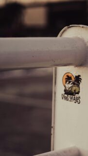 Vintage VW Van Adventure Sticker on Metal Railing Phone Wallpaper