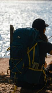 Solo Hiker Resting by the Sparkling Lake Mobile Wallpaper