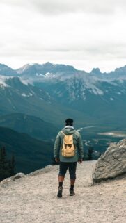 Solo Hiker Overlooking Majestic Mountain Valley Phone Wallpaper